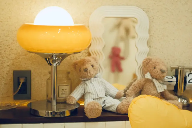 Warm nursery decor with teddy bears, lamp, and decorative elements