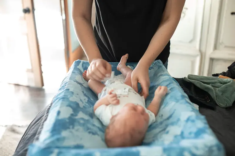 Gentle care of a newborn baby on changing table in cozy home setting