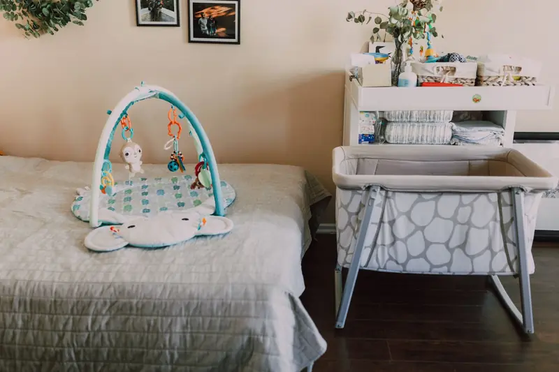 Stylish nursery with playmat, bassinet, and changing table for a cozy baby room