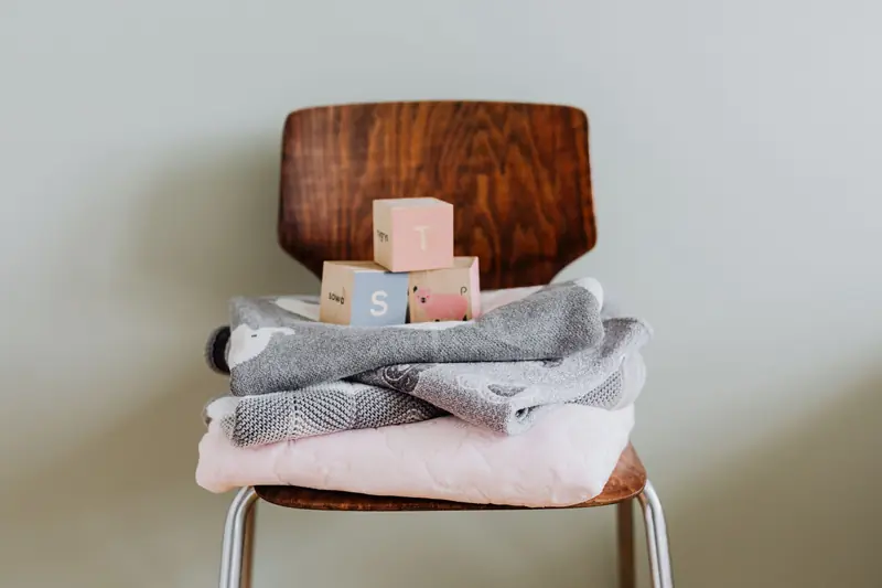 Wooden blocks and cozy baby blankets on a modern chair, ideal for nursery decor